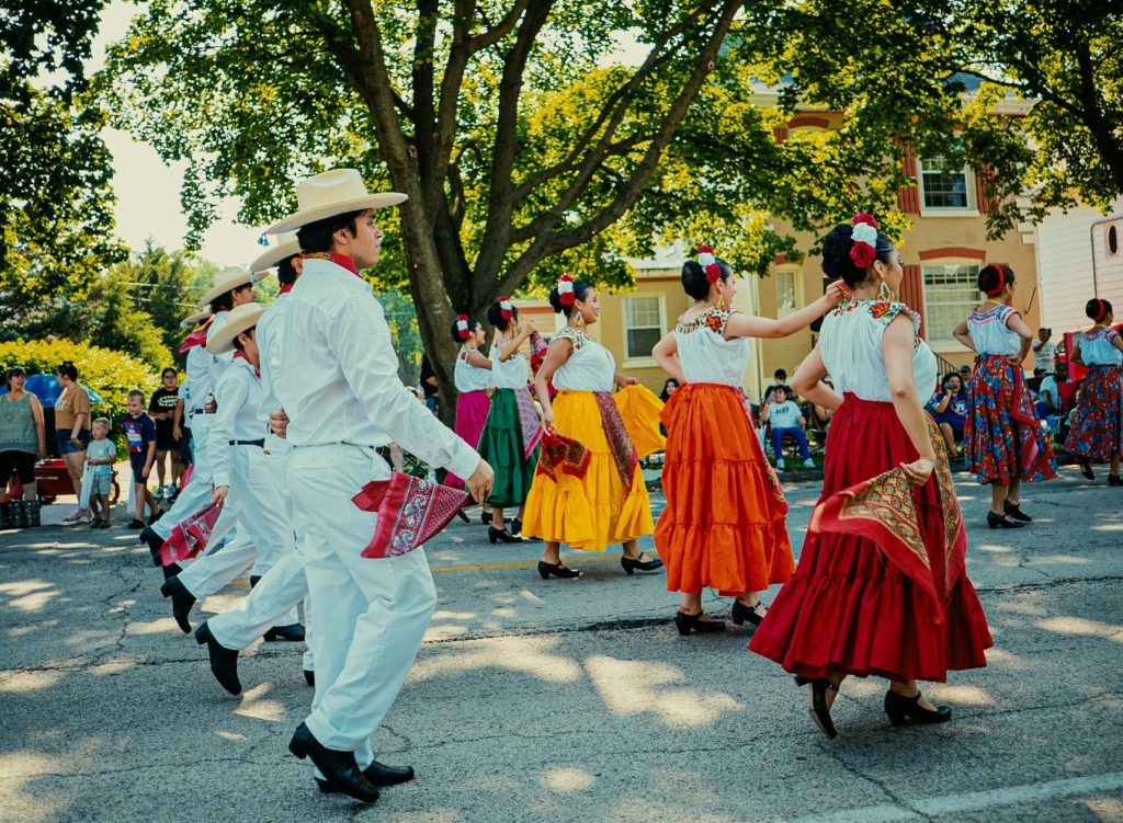 colorful hispanic dancers walking on street