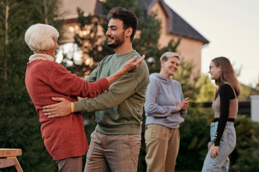 group of 4 people hugging and talking